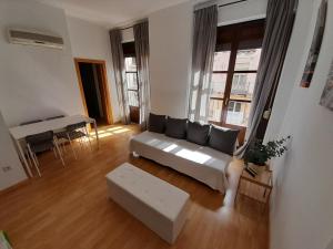 sala de estar con sofá y mesa en Apartamentos Dos Torres Pilar - Balcones con vistas al Pilar, en Zaragoza