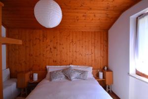 um quarto com uma cama e uma parede de madeira em B&B Claudia em Romeno