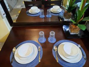a table with blue and white plates and forks and spoons at Very Homey! in Manila