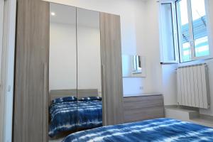 1 dormitorio con cama y espejo grande en Home Sweet Home en Civitavecchia