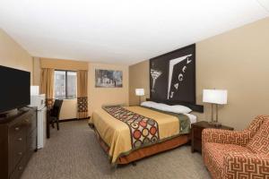 a hotel room with a bed and a chair at Super 8 by Wyndham Wichita North in Wichita