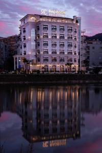 Radisson Collection Morina Hotel, Tirana في تيرانا: مبنى ينعكس على هيئة ماء