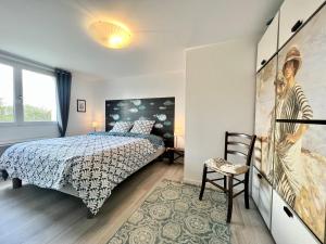 een slaapkamer met een bed en een schilderij aan de muur bij COC - Villa Le Grand Terrain - Vue Mer in Wissant