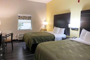 Cette chambre comprend 2 lits et une table. dans l'établissement Wingate by Wyndham Biloxi - Ocean Springs, à Biloxi