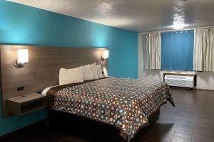 Habitación de hotel con cama y pared azul en Baymont by Wyndham Bellevue - Omaha, en Bellevue