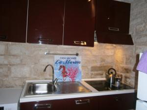 a kitchen sink with a sign that says cafe wave for marine at Appartamento vacanze La Marina in Giovinazzo