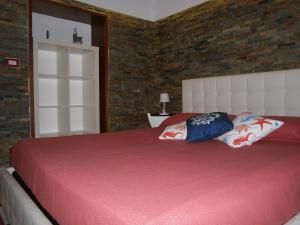 a bedroom with a large bed with red sheets and pillows at Appartamento vacanze La Marina in Giovinazzo