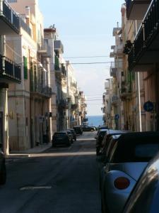 a city street with cars parked on the side of the road at Appartamento vacanze La Marina in Giovinazzo