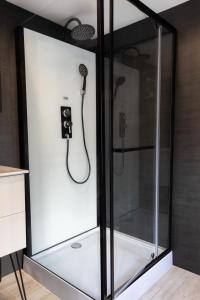 a glass shower with a shower head in a room at Chez Flo in Saint-Aignan