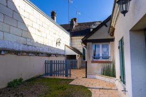 um beco entre dois edifícios com uma cerca em Chez Flo em Saint-Aignan