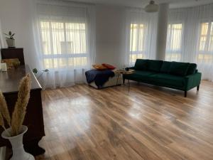 a living room with a green couch and wooden floors at Apartamento Dakota in Sant Carles de la Ràpita