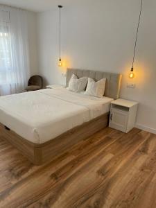 ein Schlafzimmer mit einem großen Bett und Holzboden in der Unterkunft Apartamento Dakota in Sant Carles de la Ràpita