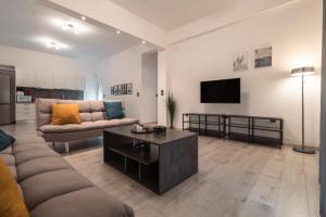 uma sala de estar com um sofá e uma televisão em Urban Serenity Gem in Kallithea neighbourhood! em Atenas