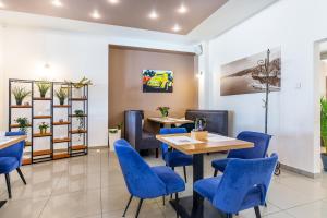 a restaurant with blue chairs and tables in a room at Hotel Dobczyce in Dobczyce