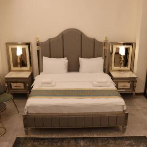 een slaapkamer met een groot bed en 2 spiegels bij Haden Hotel in Erbil