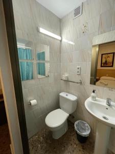 a bathroom with a white toilet and a sink at Hostal Milmarcos in Zaragoza