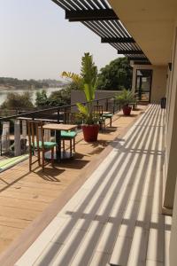 a deck with tables and chairs on a building at Au bord de l'eau in Bamako