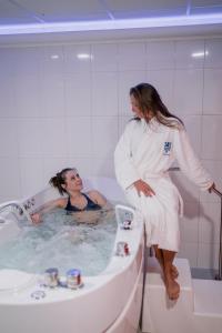 a woman standing in a bath tub next to a man at Hotel Thermal in Karlovy Vary