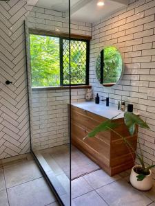 a bathroom with a shower and a sink and a window at Tranquil Rainforest Studio Kuranda in Kuranda