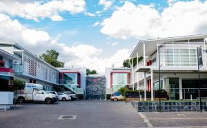 a parking lot with cars parked in front of buildings at Urban Oasis Apartments at Paragon in Windhoek