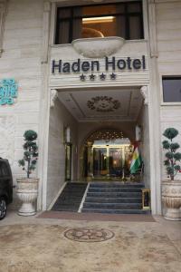 a hotel entrance with a flag in front of it at Haden Hotel in Erbil