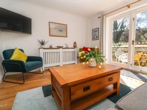 a living room with a coffee table and a chair at 'Riverside' Summercourt in Penryn