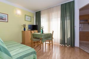 a bedroom with a bed and a table and a room at Marija F2 Apartment in Krk