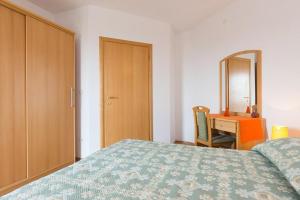a bedroom with a bed and a dresser and a mirror at Marija F2 Apartment in Krk