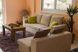 een woonkamer met een bank en een tafel bij Ozone Complex by A&D Properties in Porto Rafti