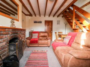 a living room with a couch and a fireplace at Keepers Cottage, 21 Coppergate in Nafferton