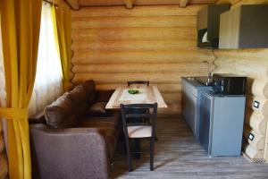 ein Zimmer mit einem Sofa und einem Tisch sowie einer Küche in der Unterkunft Cabanele Petran in Borşa
