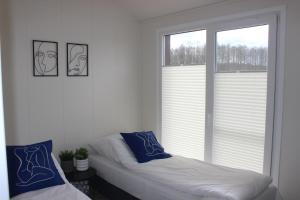 a white room with two beds and two windows at Marina Houses in Ruciane-Nida