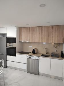 eine Küche mit weißen Schränken und Geräten aus Edelstahl in der Unterkunft Casinha das Bonecas By Viva a Vida - Alojamentos & Hotels in Constância