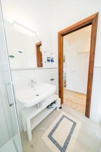 bagno bianco con lavandino e specchio di Casa Alessandra a Ravello
