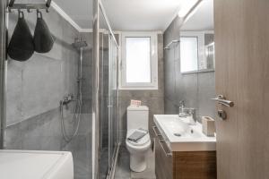 uma casa de banho com um chuveiro, um WC e um lavatório. em Urban Serenity Gem in Kallithea neighbourhood! em Atenas