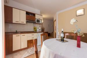 eine Küche mit einem Tisch und einer Flasche Wein in der Unterkunft Marija F4 Apartment in Krk