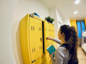 a woman standing in front of a yellow locker at QUO Milano in Milan