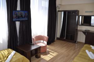 a hotel room with a chair and a desk at Vila Julia Costinesti in Costinesti