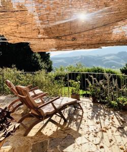 a patio with a chair and a wooden umbrella at Relais B&B Betty Bike in Sasso Feltrio