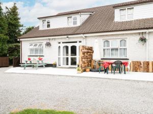 a white house with a table and chairs in front of it at Kiltartan House in Ballina