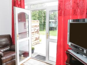 an open sliding glass door with a tv and a sliding glass door at Kiltartan House in Ballina