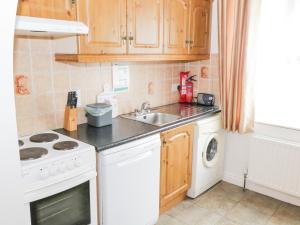 a kitchen with a white stove top oven next to a sink at Kiltartan House in Ballina