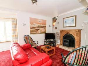 sala de estar con sofá rojo y chimenea en Ballysheen House, en Rosslare