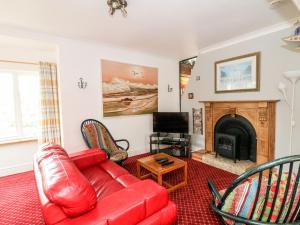 a living room with a red couch and a fireplace at Ballysheen House in Rosslare