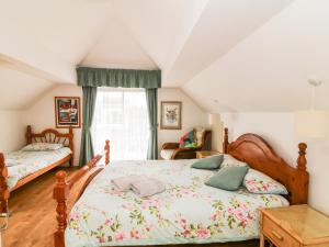 a bedroom with two beds and a window at Ballysheen House in Rosslare