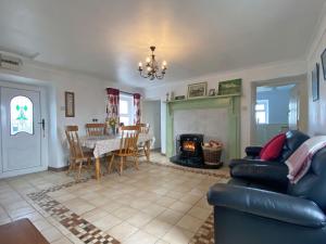 a living room with a couch and a table and a fireplace at Cottage 429 - Ballyconneely in Ballyconneely