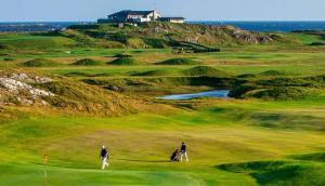 two people playing golf on a golf course at Cottage 429 - Ballyconneely in Ballyconneely