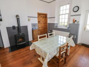 uma sala de jantar com uma mesa e um fogão em The Old School House em Carrigallen