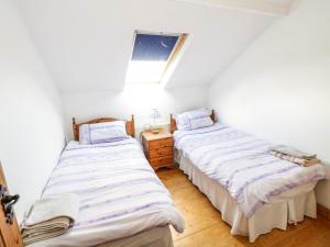 2 camas individuales en una habitación con ventana en The Old School House en Carrigallen