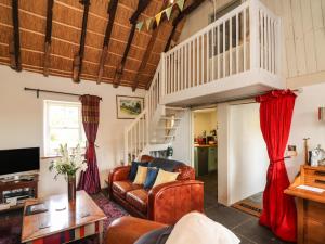 a living room with a couch and a staircase at New Thatch Farm in Knocklong
